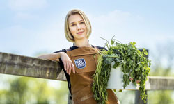 Dairy Farmers of America female veterinarian holding a pot of long green herbs
