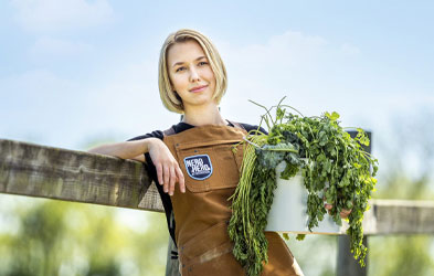Dairy Farmers of America female veterinarian holding a pot of long green herbs