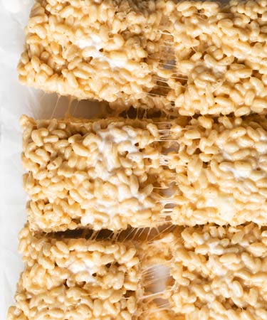Three rice krispies treats being pulled apart from the center  
