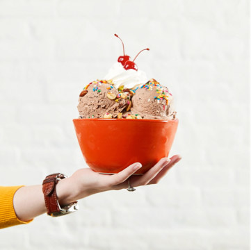 Bowl of ice cream with sprinkles and cherry